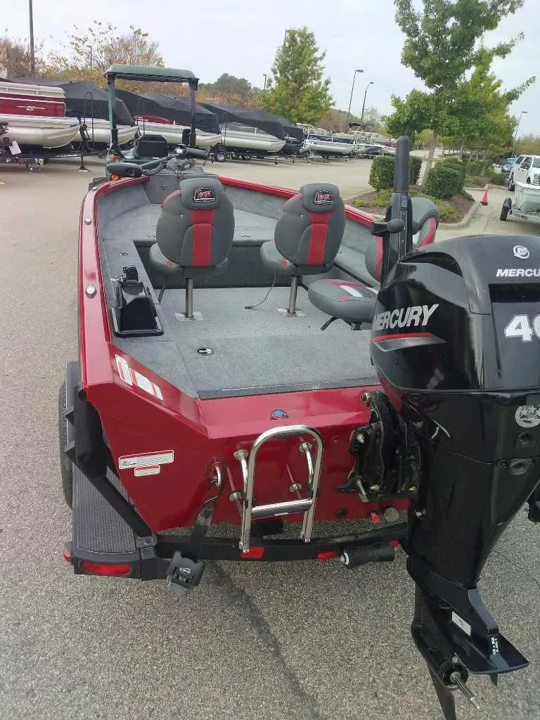 Slide: The Image of 2024 Ranger VS1665T boat with Mercury 40 engine, red exterior, parked outdoors. - 1