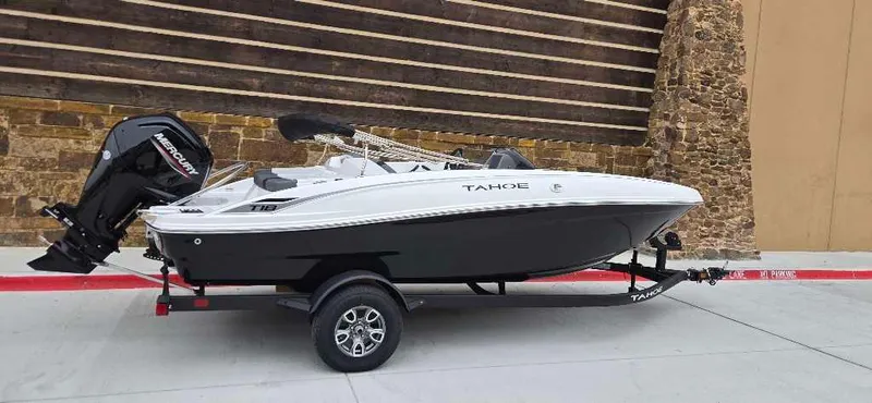 Slide: The Image of 2025 Tahoe T18 boat on trailer, black and white design, parked outdoors. - 1