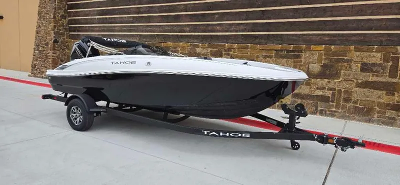 Slide: The Image of 2025 Tahoe T18 boat on trailer, sleek design, black and white color scheme. - 2