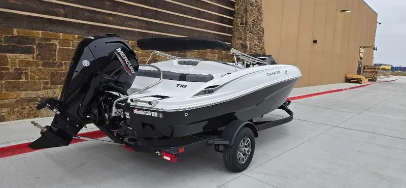 Slide: The Image of 2025 Tahoe T18 boat on trailer, parked outdoors, featuring sleek design and powerful engine. - 4