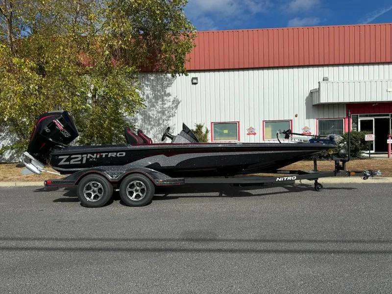 The Image of 2025 Nitro Z21 XL boat on trailer, parked outside industrial building. - 0