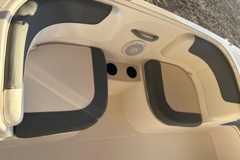 Slide: The Image of 2025 Bayliner E18LE boat interior with cushioned seating and cup holders. - 10