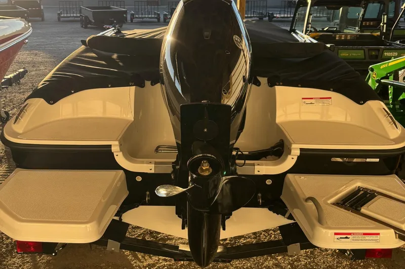 Slide: The Image of 2025 Bayliner E18LE boat rear view with covered seating and outboard motor. - 11