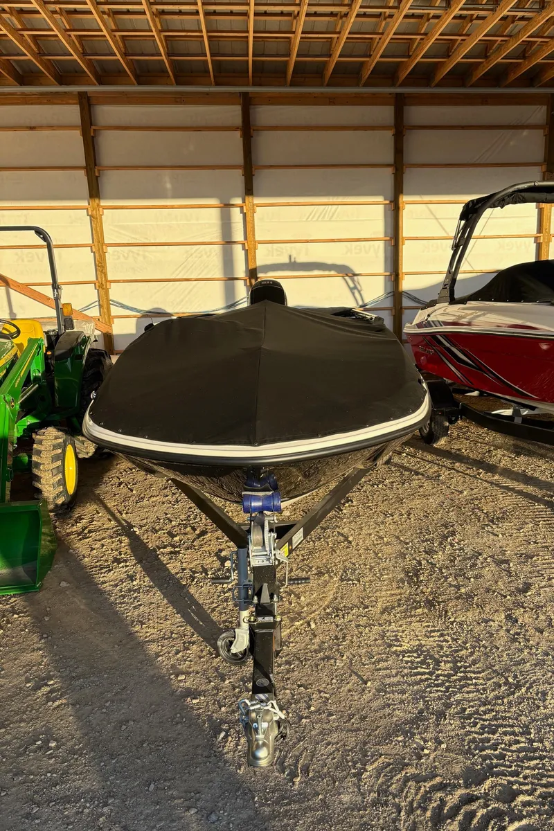 Slide: The Image of 2025 Bayliner E18LE boat covered in storage, front view. - 2