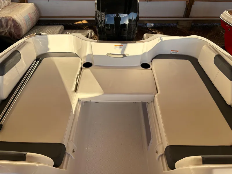 Slide: The Image of 2025 Bayliner E18LE boat interior with cushioned seating and storage compartments. - 3