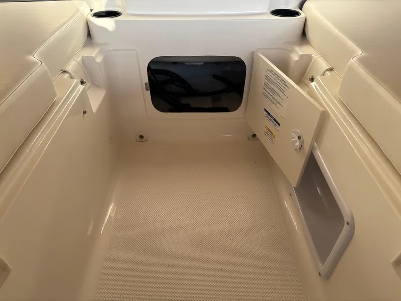 Slide: The Image of 2025 Bayliner E18LE boat interior with storage compartment and seating area. - 4