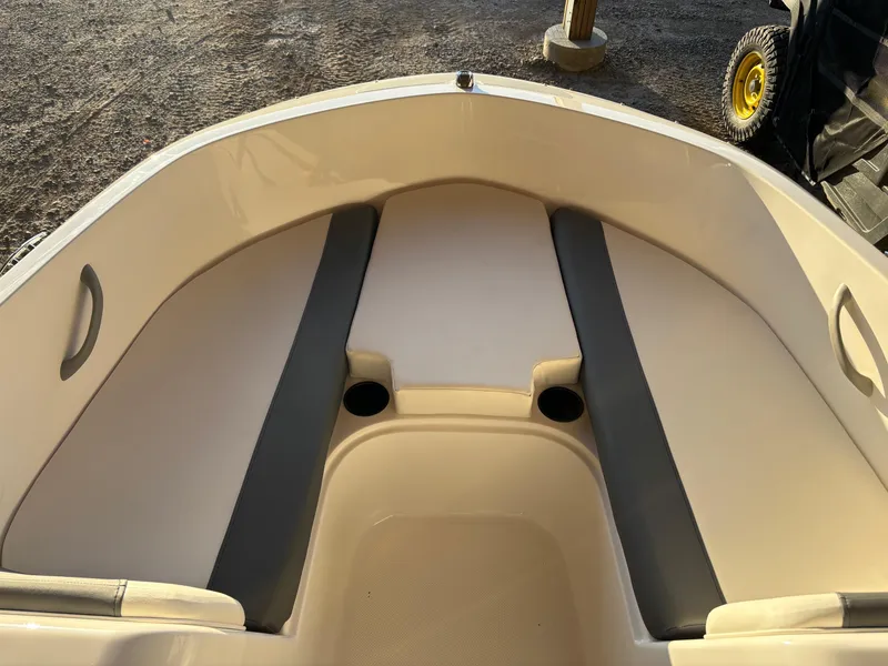 Slide: The Image of 2025 Bayliner E18LE boat interior with cushioned seating and cup holders. - 6