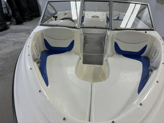 Slide: The Image of 2007 Bayliner 175 Bowrider interior with blue and white seating, windshield, and spacious layout. - 14