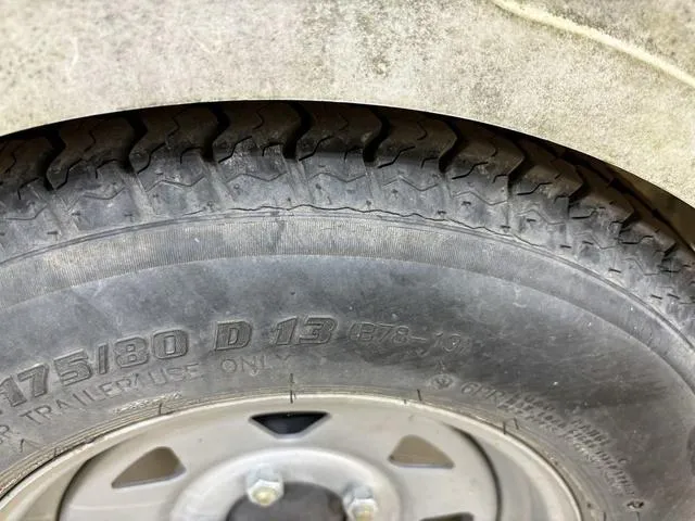 Slide: The Image of Close-up of a 2007 Bayliner 175 Bowrider trailer tire with visible tread and markings. - 6