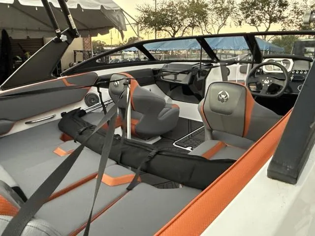 Slide: The Image of 2025 Scarab 195 LX boat with orange accents on a trailer, parked outdoors. - 10