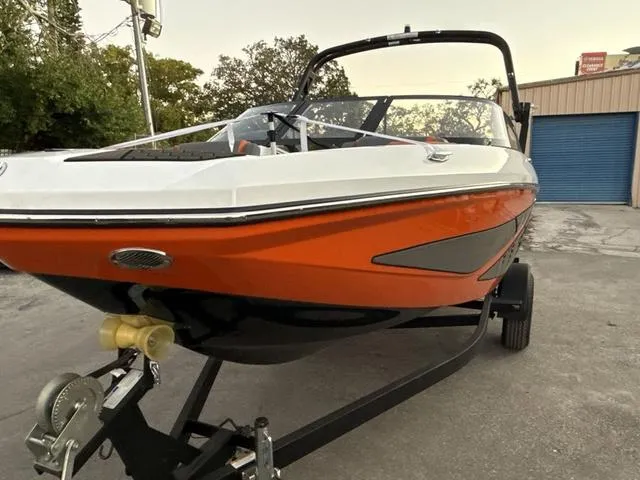 Slide: The Image of 2025 Scarab 195 LX boat on trailer, vibrant orange and black design. - 4