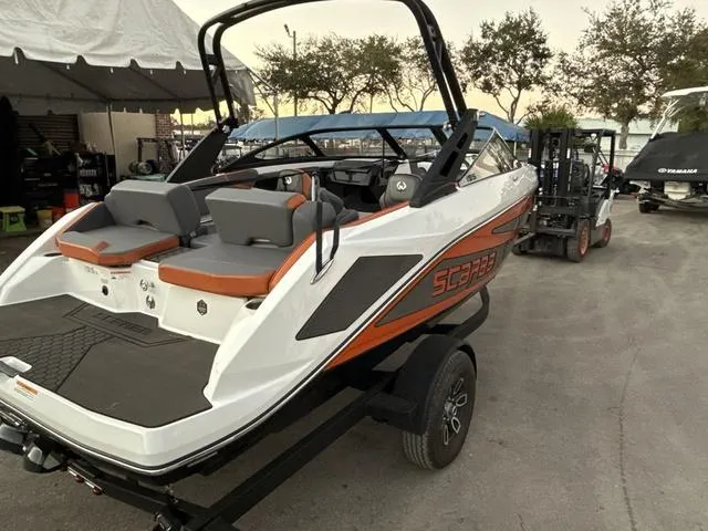 Slide: The Image of 2025 Scarab 195 LX boat with gray and orange seating, parked outdoors. - 9