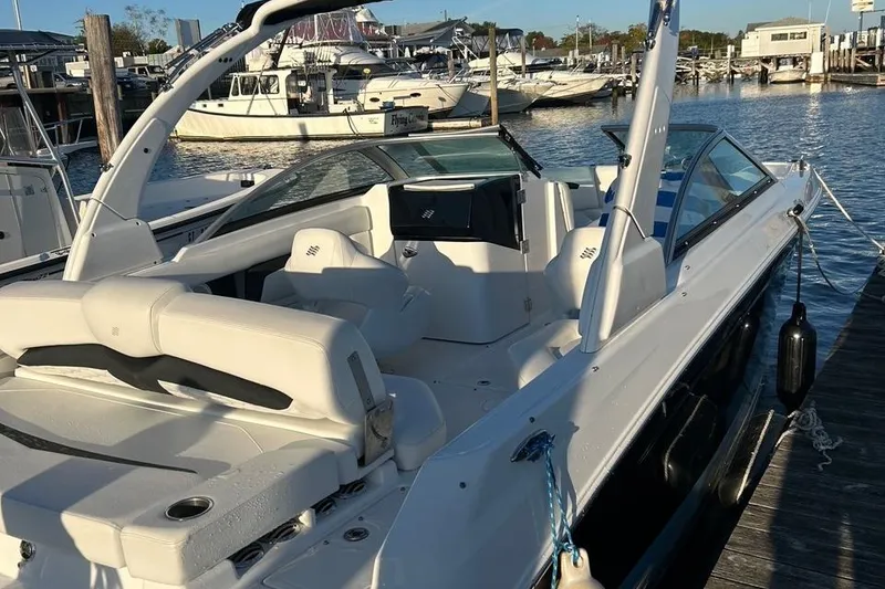 Slide: The Image of 2022 Four Winns HD3 OB RS boat docked at marina, featuring sleek design and spacious seating. - 4