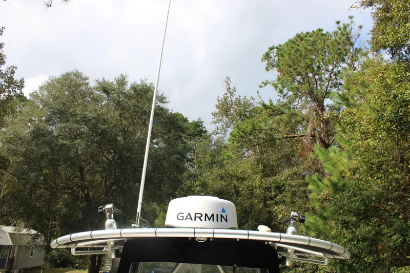 Slide: The Image of 2009 Sea Fox 256CC Pro Series boat with Garmin radar, surrounded by lush trees. - 23