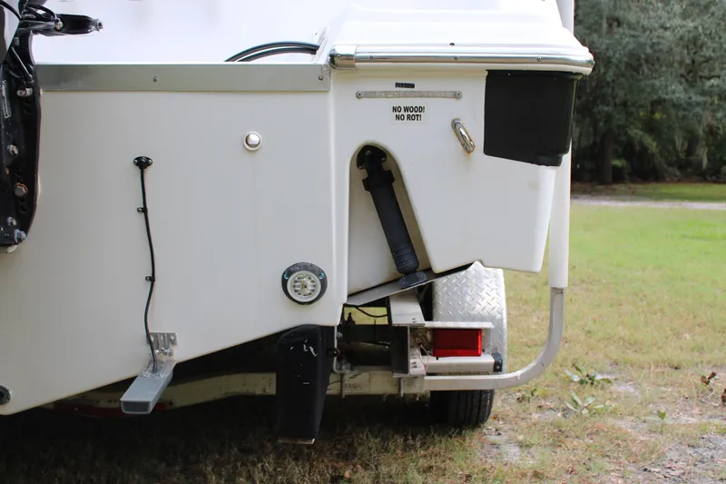 Slide: The Image of 2009 Sea Fox 256CC Pro Series boat trailer detail, showing rear components and grassy background. - 48