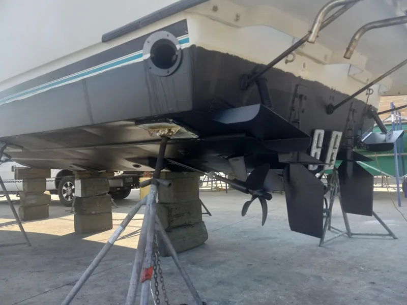 Slide: The Image of 1997 Bayliner 3255 Avanti boat on blocks, showing hull and propellers. - 12