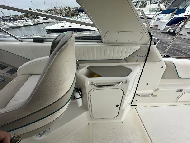 Slide: The Image of 1997 Bayliner 3255 Avanti boat interior with seating and storage, docked at marina. - 13