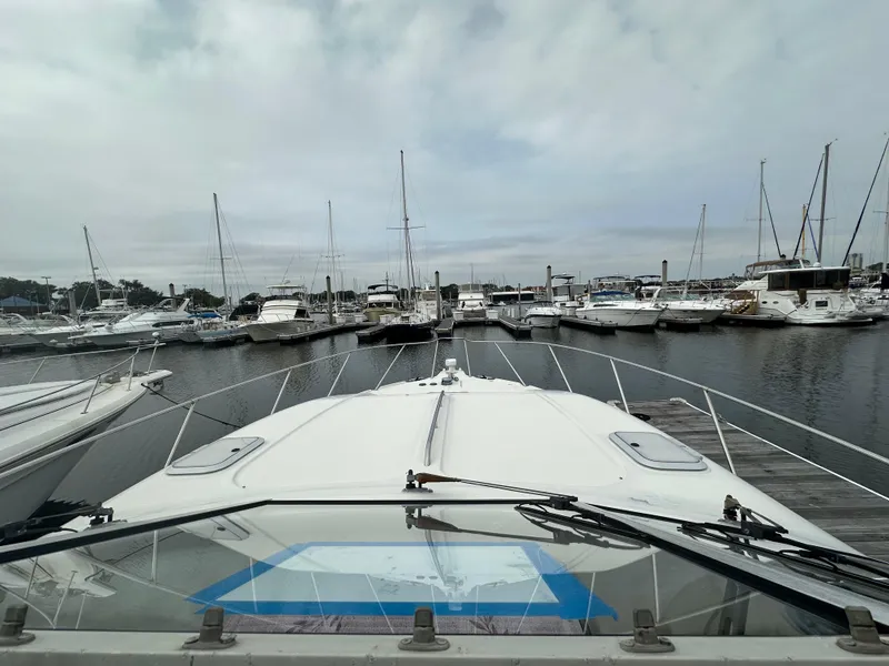 Slide: The Image of 1997 Bayliner 3255 Avanti docked at marina with multiple boats. - 16