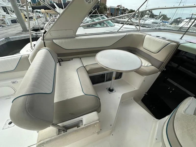 Slide: The Image of 1997 Bayliner 3255 Avanti boat interior with cushioned seating and round table. - 17