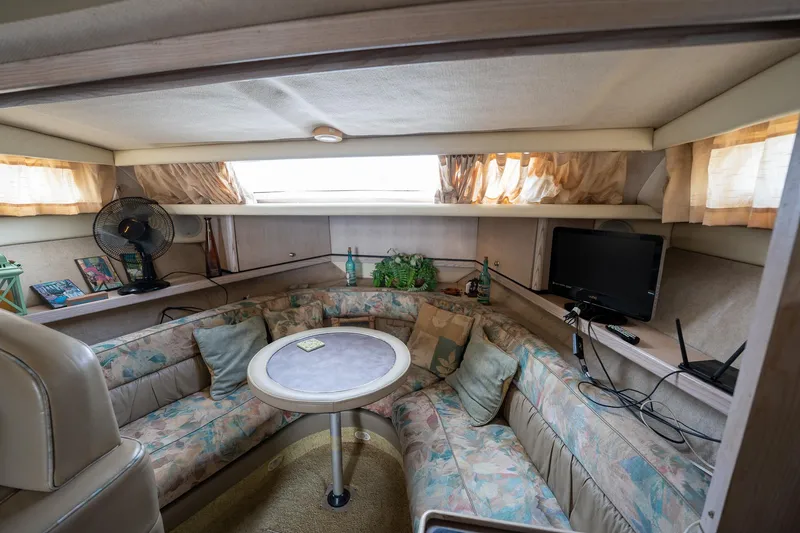 Slide: The Image of Interior of 1997 Bayliner 3255 Avanti with cozy seating, table, and TV. - 27