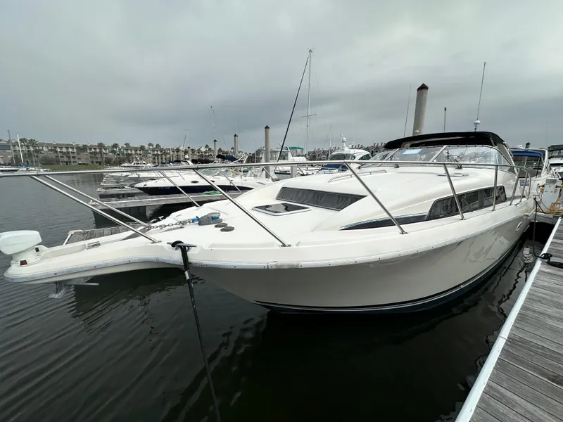 Slide: The Image of 1997 Bayliner 3255 Avanti boat docked in marina, overcast sky. - 3