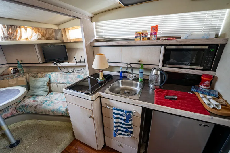 Slide: The Image of Interior of a 1997 Bayliner 3255 Avanti boat with kitchenette and seating area. - 32