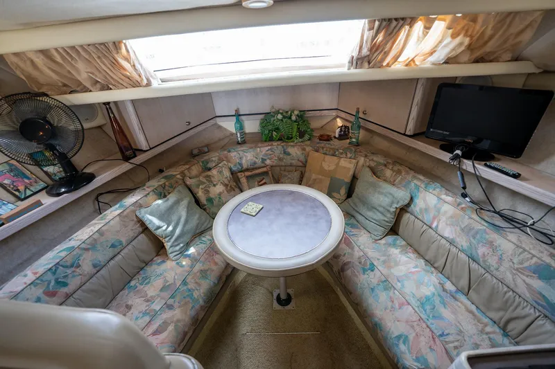 Slide: The Image of Interior of 1997 Bayliner 3255 Avanti with cozy seating, table, and decor. - 33
