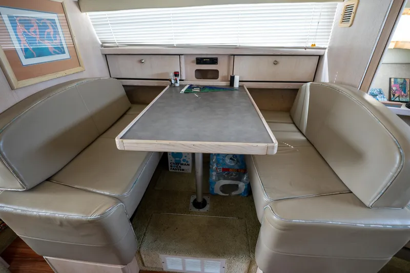 Slide: The Image of Interior of 1997 Bayliner 3255 Avanti with dining area and beige seating. - 34