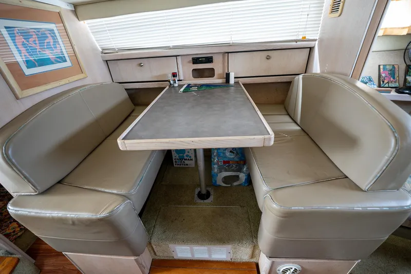 Slide: The Image of 1997 Bayliner 3255 Avanti interior with beige leather seating and dining table. - 35