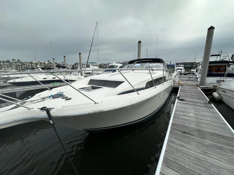 Slide: The Image of 1997 Bayliner 3255 Avanti docked at marina under cloudy sky. - 4