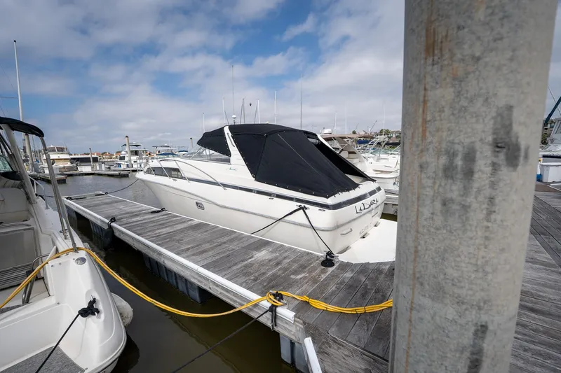 Slide: The Image of 1997 Bayliner 3255 Avanti docked at marina under cloudy sky. - 45