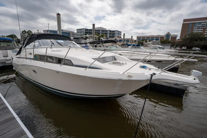 Slide: The Image of 1997 Bayliner 3255 Avanti docked at a marina under cloudy skies. - 5