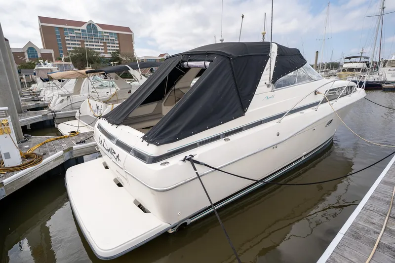 Slide: The Image of 1997 Bayliner 3255 Avanti docked at marina with black canopy. - 7