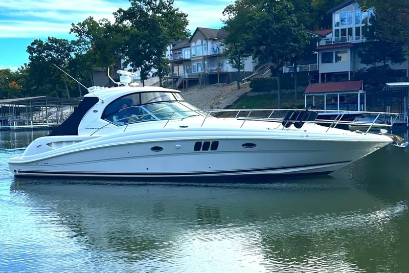 Slide: The Image of 2007 Sea Ray 44 Sundancer yacht on calm water near lakeside homes. - 0