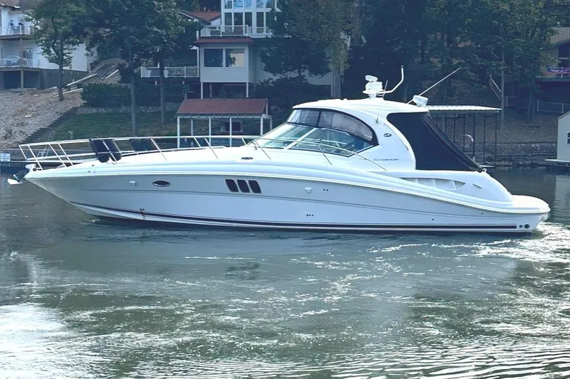 Slide: The Image of 2007 Sea Ray 44 Sundancer yacht on calm water near shoreline. - 1