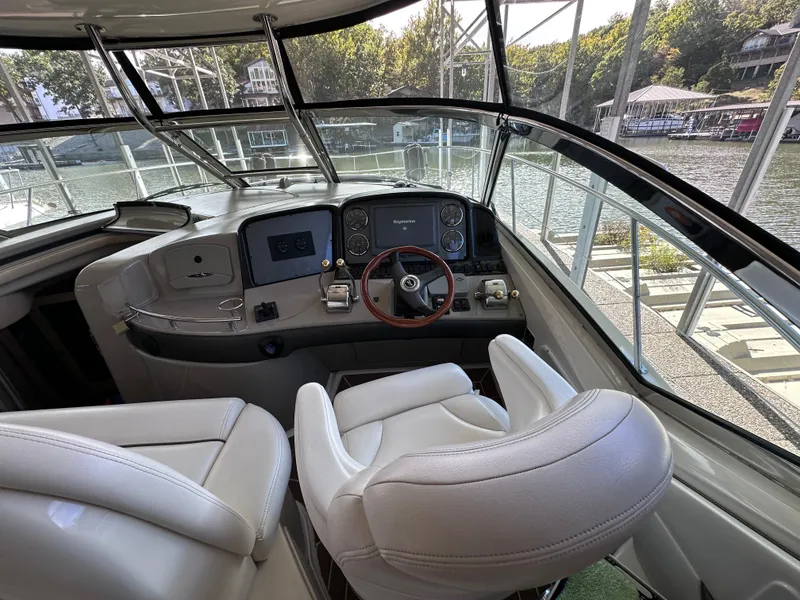 Slide: The Image of 2007 Sea Ray 44 Sundancer helm with white leather seats and modern controls. - 12