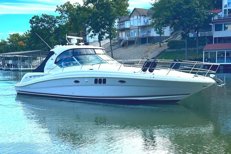 Slide: The Image of 2007 Sea Ray 44 Sundancer yacht docked on calm water near waterfront homes. - 2