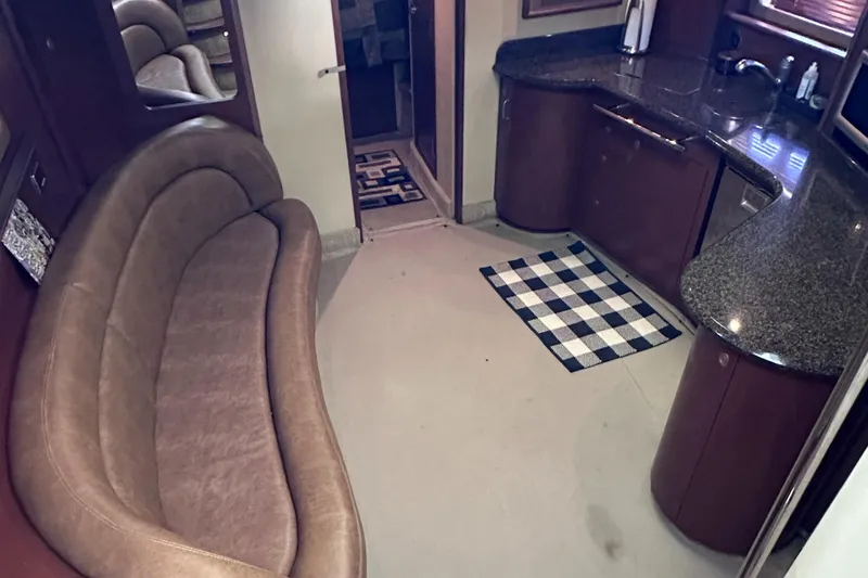 Slide: The Image of Interior of 2007 Sea Ray 44 Sundancer yacht with curved sofa and kitchenette. - 25