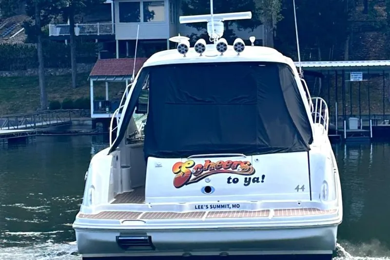 Slide: The Image of 2007 Sea Ray 44 Sundancer yacht on water, rear view, docked near houses. - 5