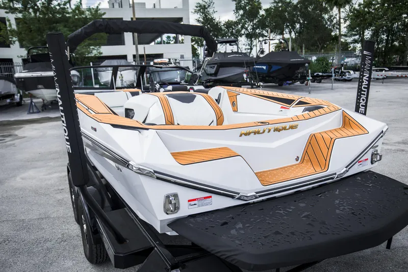 Slide: The Image of 2025 Nautique Ski boat with sleek design and modern features, parked outdoors. - 10