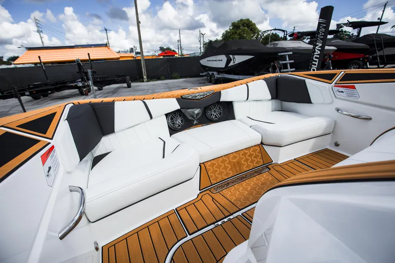 Slide: The Image of 2025 Nautique Ski boat interior with white seating and teak flooring. - 12