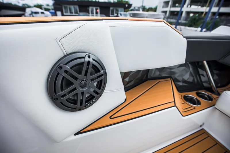 Slide: The Image of 2025 Nautique Ski boat interior with speaker and cup holders, featuring sleek design and wood accents. - 15