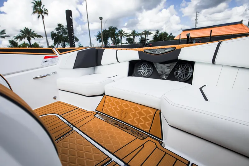 Slide: The Image of 2025 Nautique Ski boat interior with white seating and orange flooring, featuring modern design elements. - 26