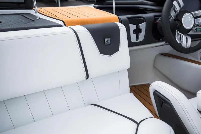 Slide: The Image of 2025 Nautique Ski boat interior with white and black seating, modern steering wheel, and wood accents. - 27