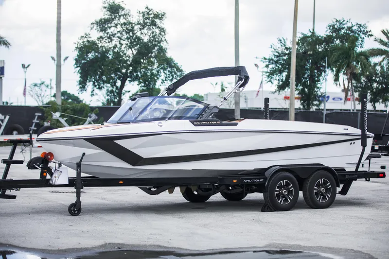 Slide: The Image of 2025 Nautique Ski boat on trailer, sleek design, parked outdoors. - 9
