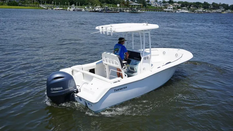 Slide: The Image of 2021 Tidewater 220 LXF boat cruising on a calm river with a Yamaha outboard motor. - 5