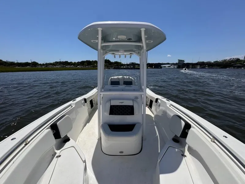 Slide: The Image of 2021 Tidewater 220 LXF boat on calm water, sunny day, spacious deck. - 8