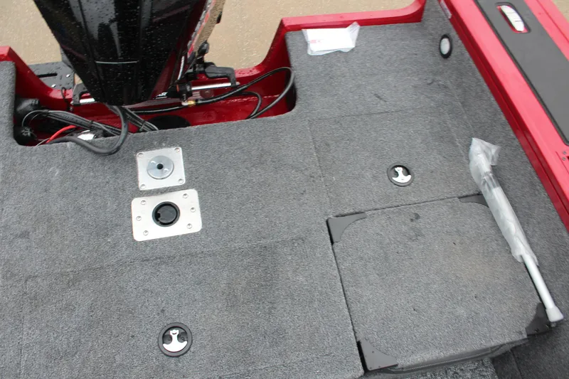 Slide: The Image of 2025 Tracker Targa V-18 Combo boat interior with gray carpet and red accents. - 19