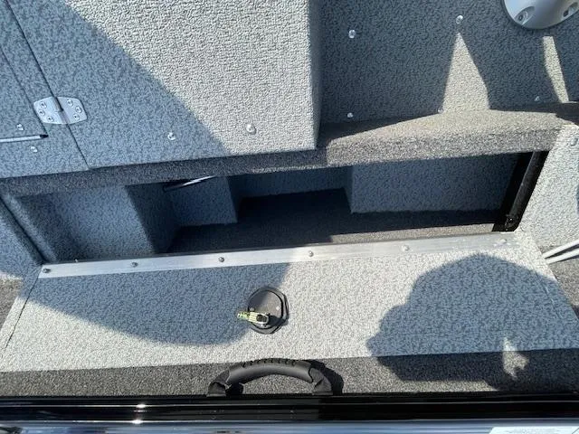 Slide: The Image of 2025 Lund 1650 Rebel XL SS boat interior storage compartment, gray carpeted finish. - 27