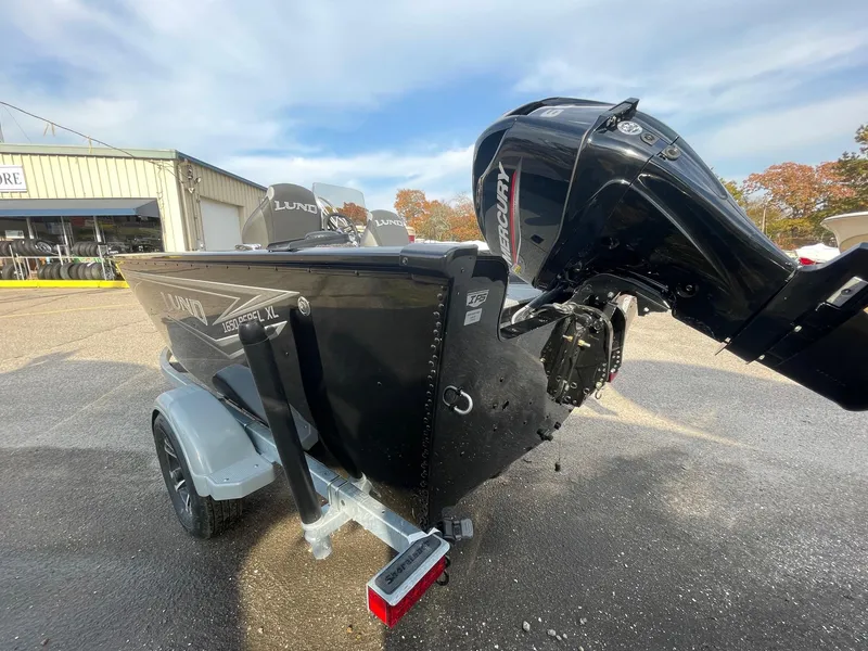 Slide: The Image of 2025 Lund 1650 Rebel XL SS boat with outboard motor, parked on a trailer. - 4